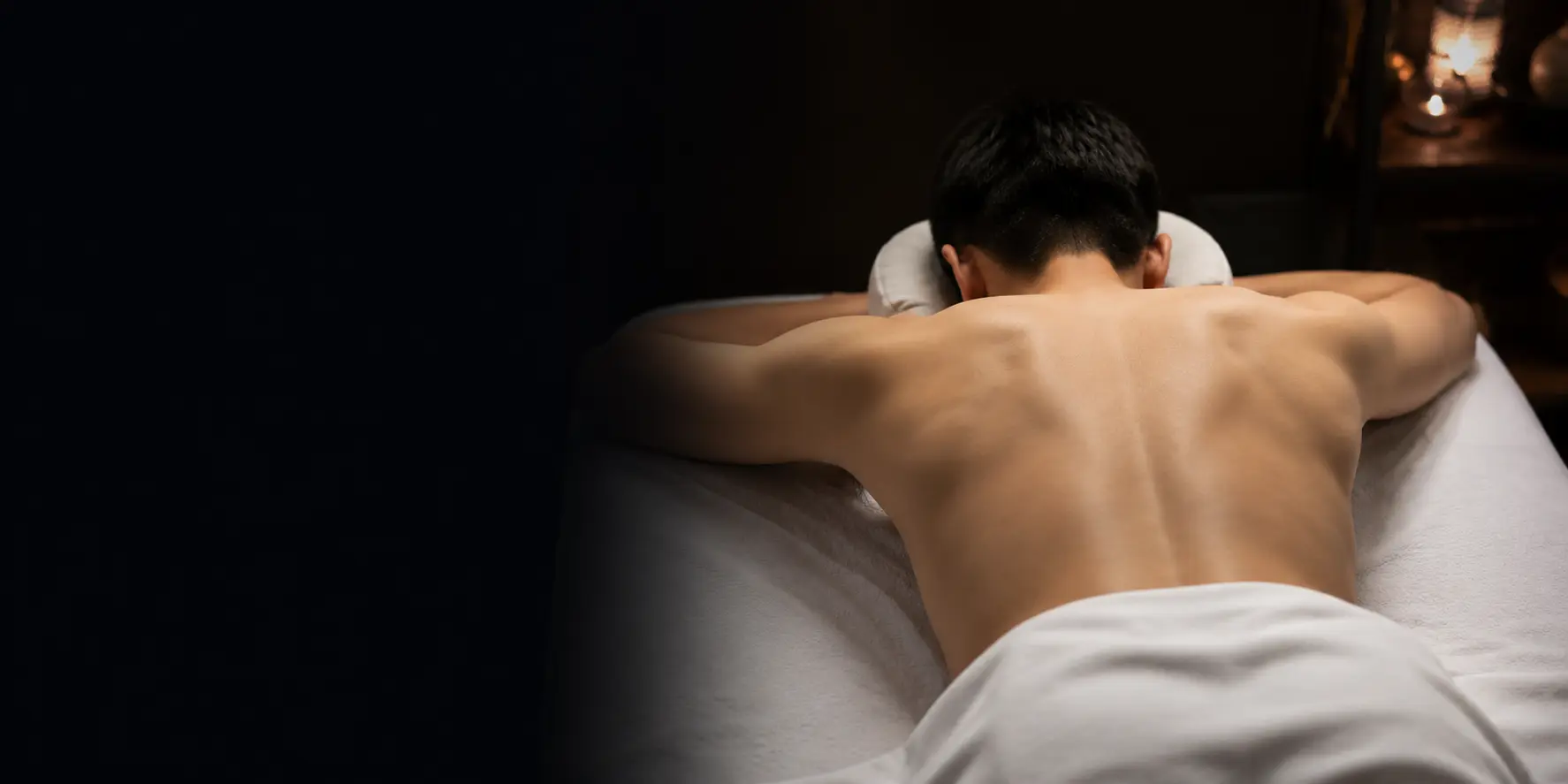 Person lying face down on a massage table in a spa treatment room