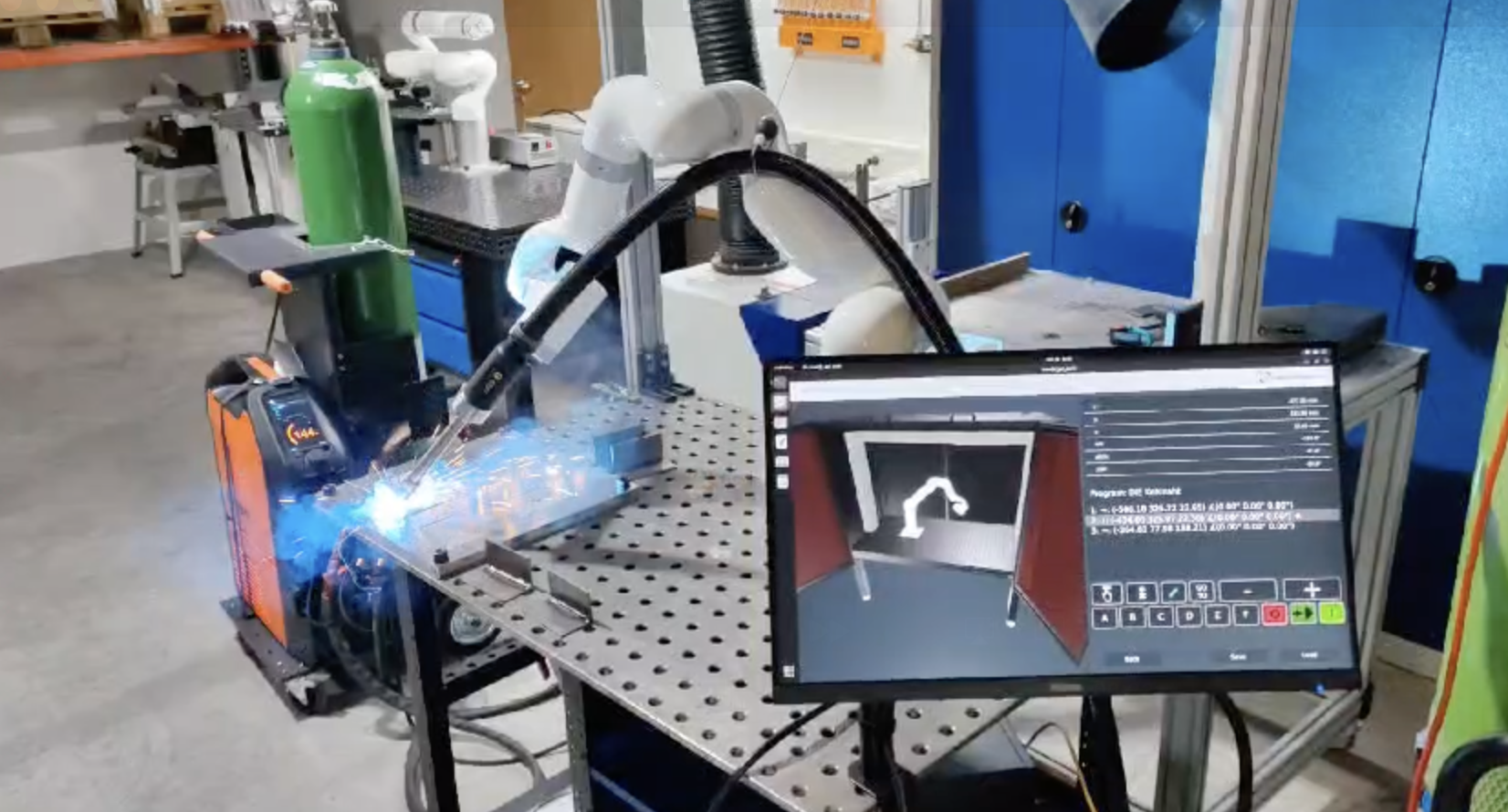 UFACTORY协作机械臂在工装台上焊接钢制组件，画面可见气瓶、焊机与烟尘净化装置