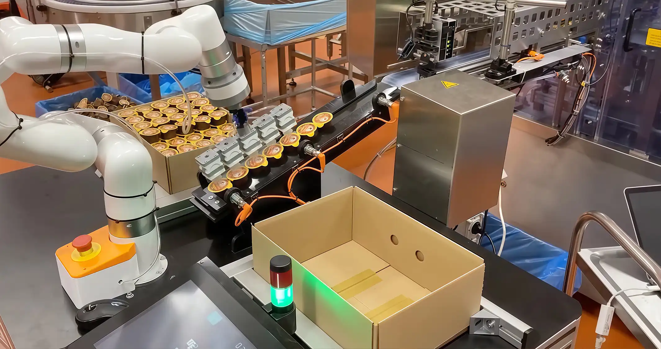 xArm robotic arm transferring a row of finished products towards a shipping carton for automated packaging