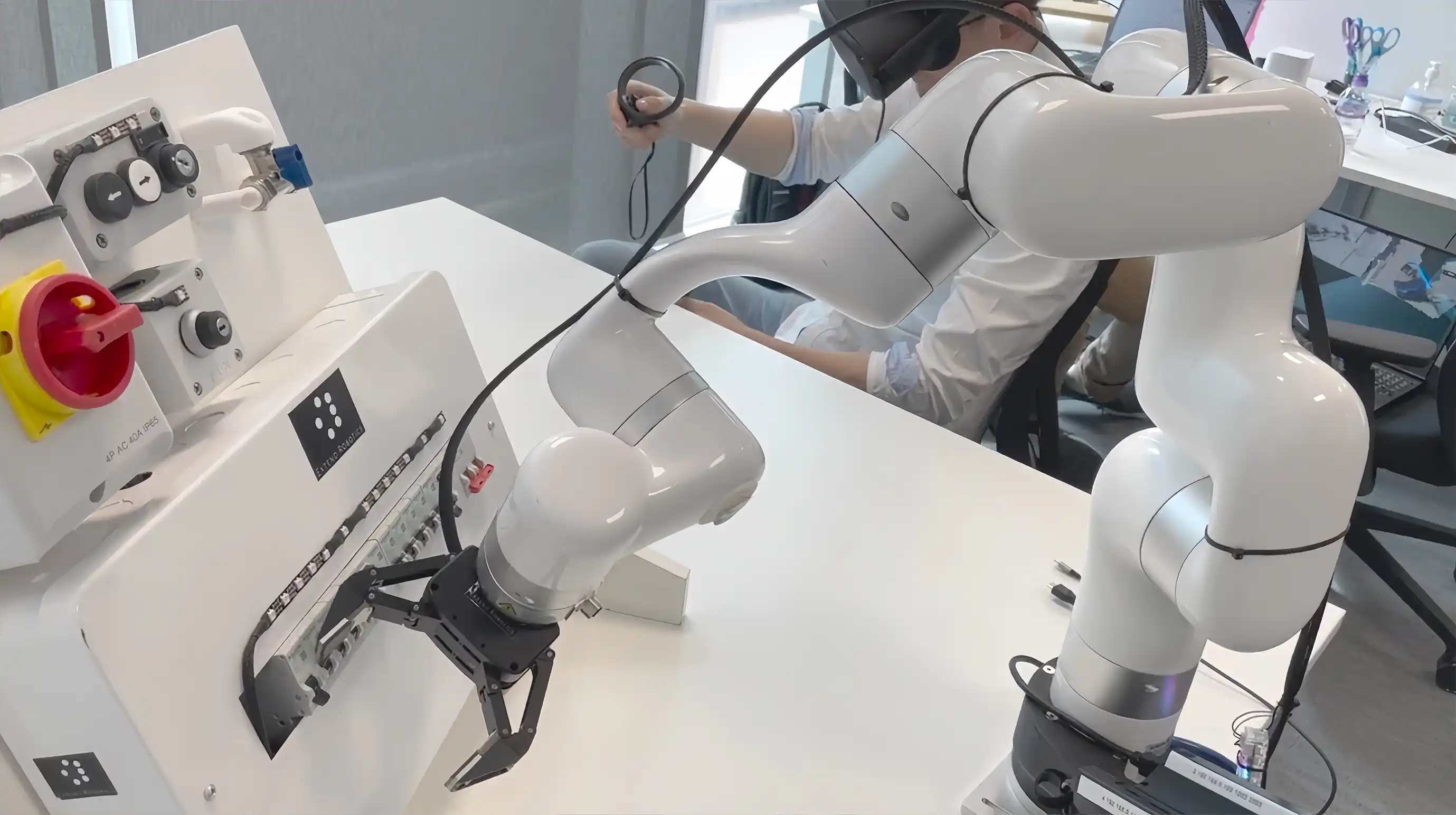 VR operator teleoperates a UFACTORY xArm with a two-finger gripper at an industrial control panel